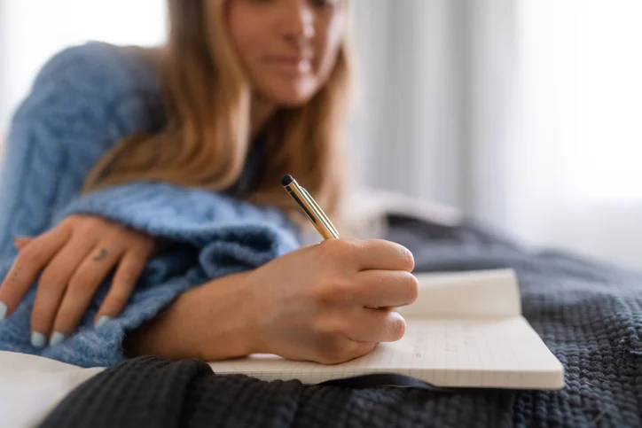 Woman writing in her journal in the morning. girl writing in notebook.2412171613073