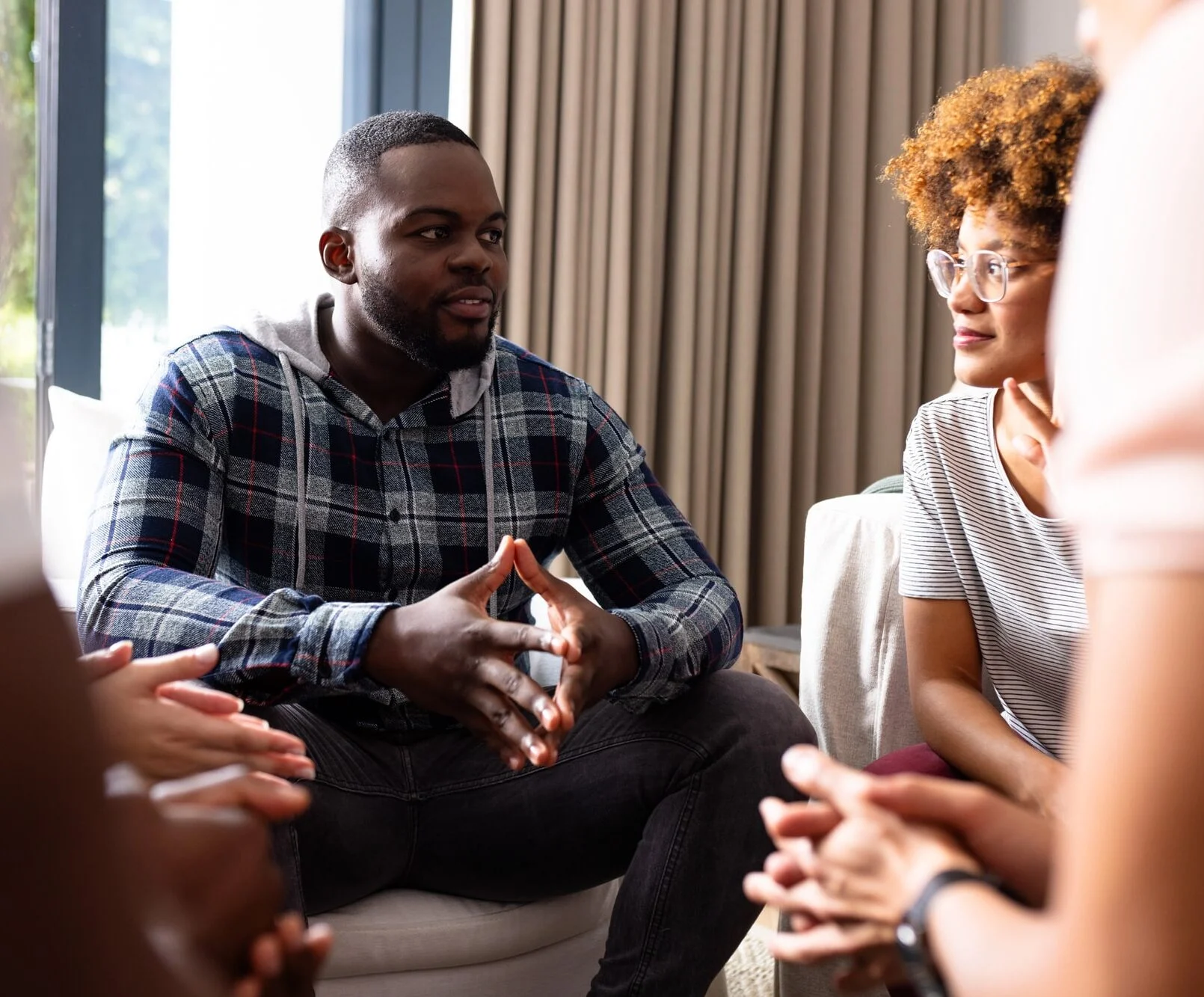 Diverse friends talking and listening to each other at group therapy