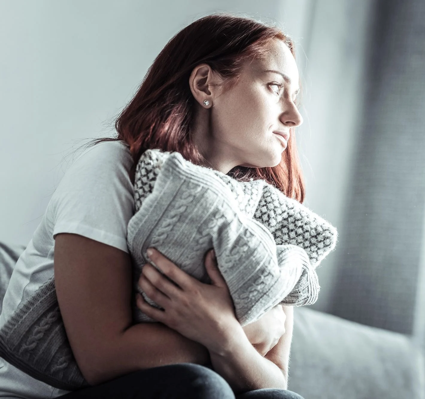 Upset female person looking out window