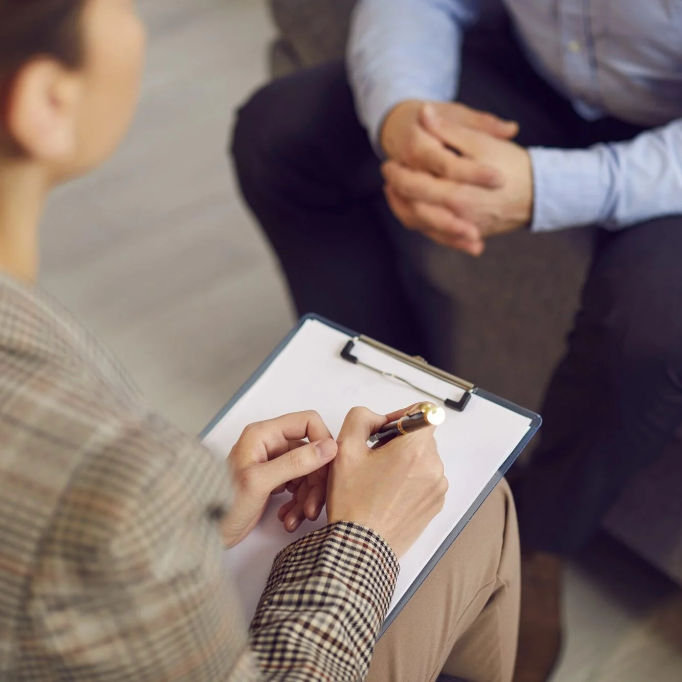 Woman therapist with a clipboard and a sheet of paper talking-min Woman therapist with a clipboard and a sheet of paper talking-min