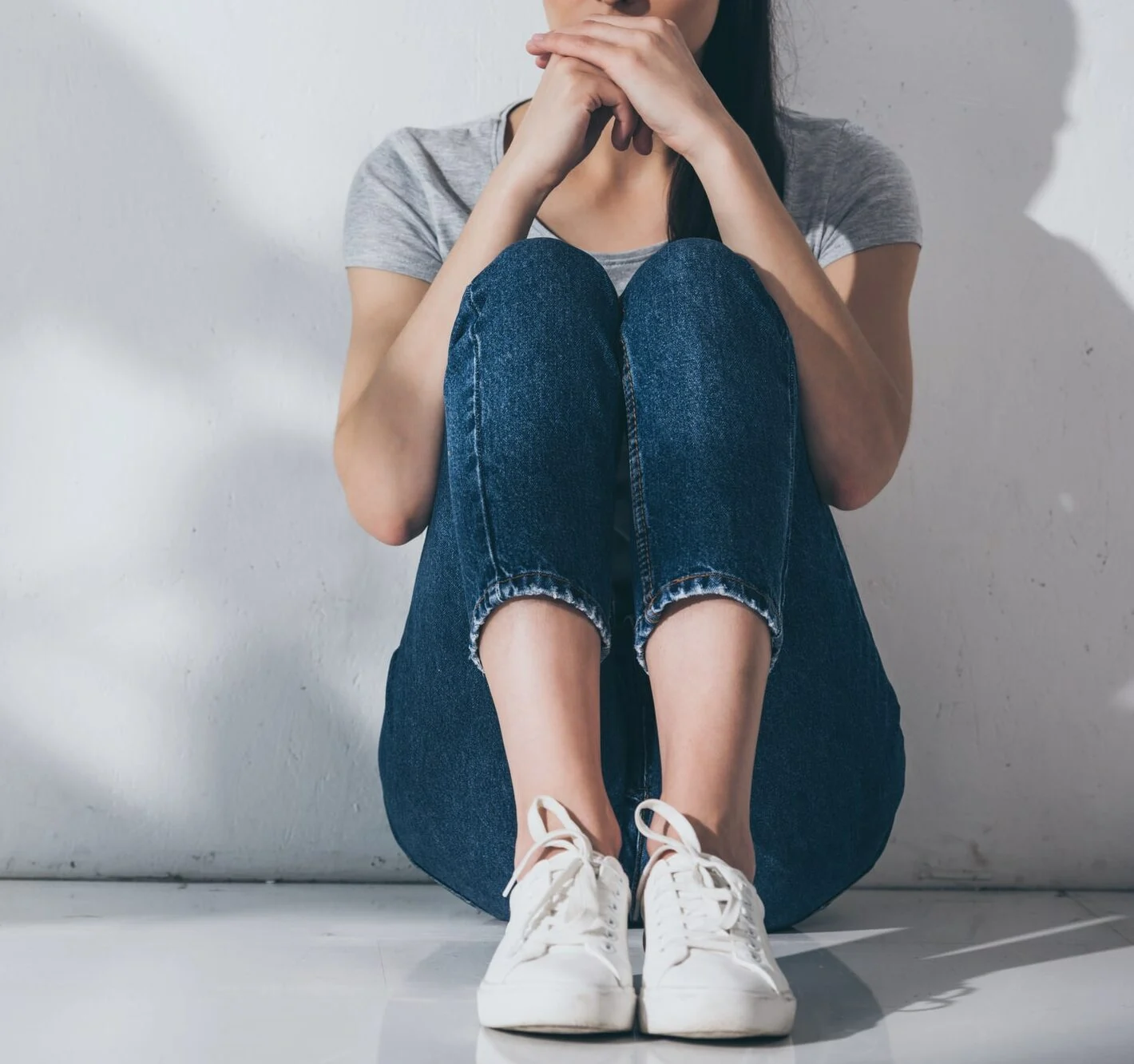 shot of panicked woman sitting on floor-min panicked woman sitting on floor